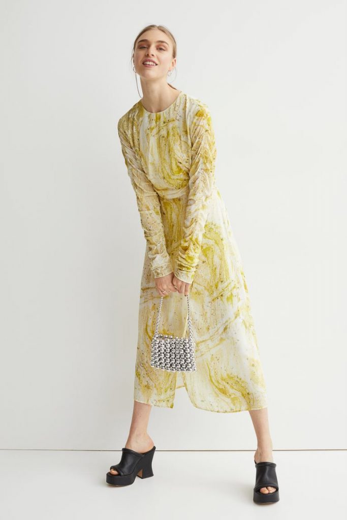viscose weave calf length dress with round neck and long sleeves with ruching effect. Wrap over dress with delicate thin ties. Yellow and white marble print. 