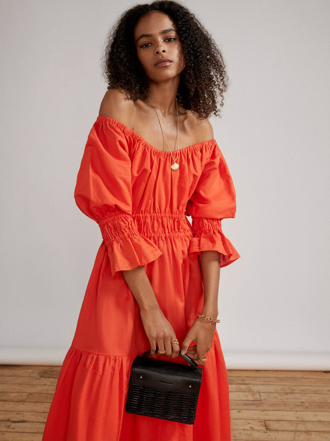 Linen Midi dress in a vibrant coral hue with elasticated panels so you can really puff up the  shirred sleeves. We’ve added a tiered, full skirt with pockets for extra ease of movement, whilst it’s lightweight linen-cotton blend will keep you cool.