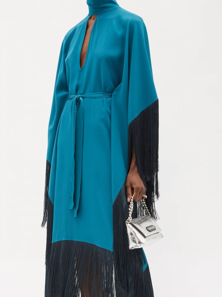 The sweeping silhouette of Taller Marmo's turquoise satin Mrs Hall kaftan dress is accentuated by swathes of long black fringing, creating elegant sway with each step. Open back, long sleeves and tie waist. High neck with keyhole. 