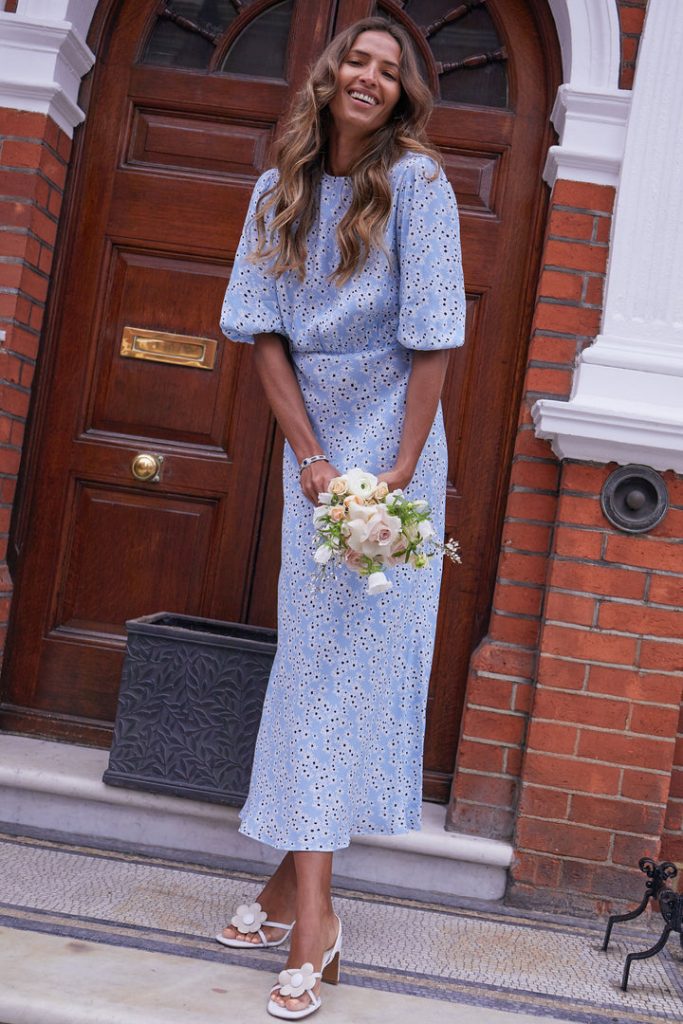Pale blue dress with white floral daisy print. Midi Length with close to the body fit, round neck, gathered waist & elbow length voluminous gathered sleeves. 
