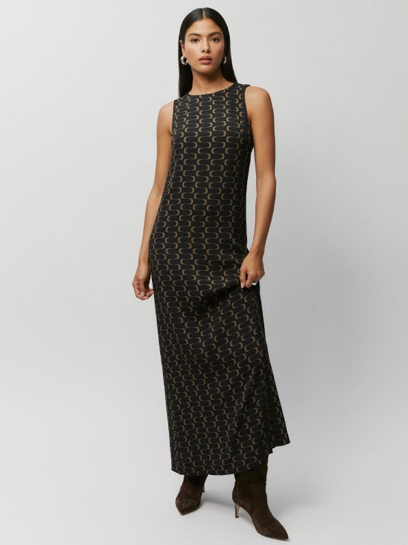 Black maxi length dress with squiggle print. Relaxed fit with crew neckline and single button closure at the back neck with a keyhole cut out. 