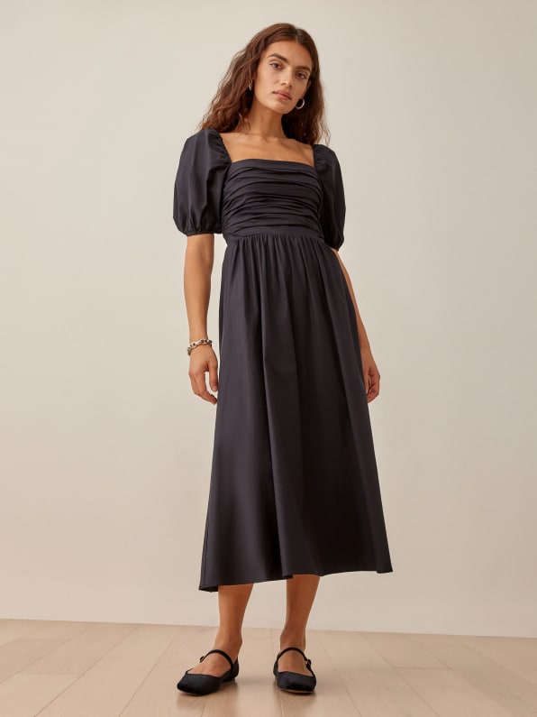 Reformation Black Midi Dress with ruched fitted bodice and puffed sleeves to elbow. Fuller skirt with room to move. 