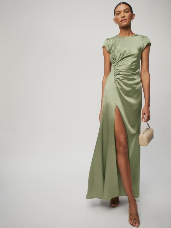 The Birch is a maxi length dress with a crew neckline. It features a high slit with ruched, button detailing to show off your figure. Artichoke Green satin. 