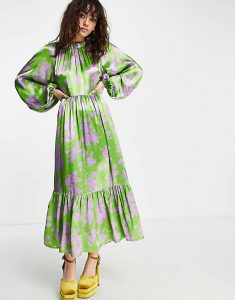 Ankle length satin dress with full length balloon sleeves, elasticated cross over back, frill hem, nipped in waist and round neck. Green with lilac abstract floral print. 