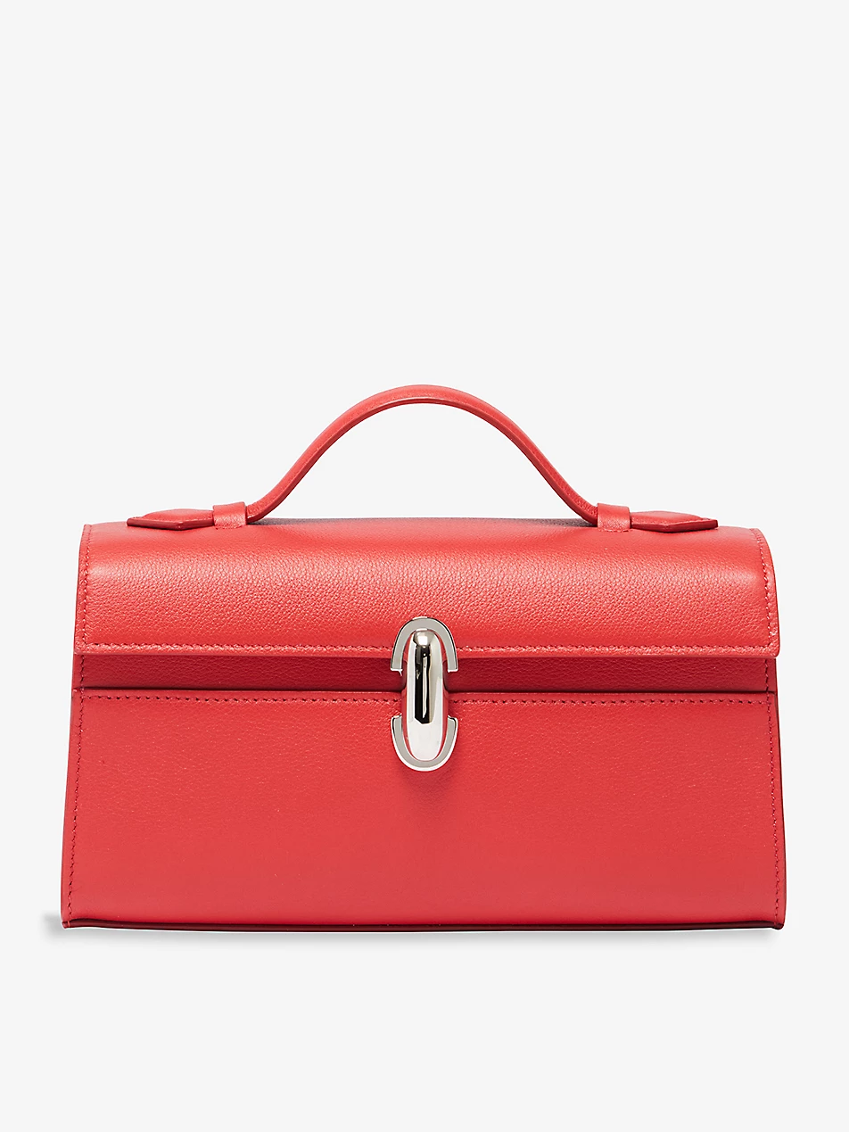 Savette red leather 100% calf leather Pochette top handle bag. Twist lock fastening at front. Top handle, front flap, concealed foiled branding at front, one main compartment, one slip pocket at interior, silver-toned hardware