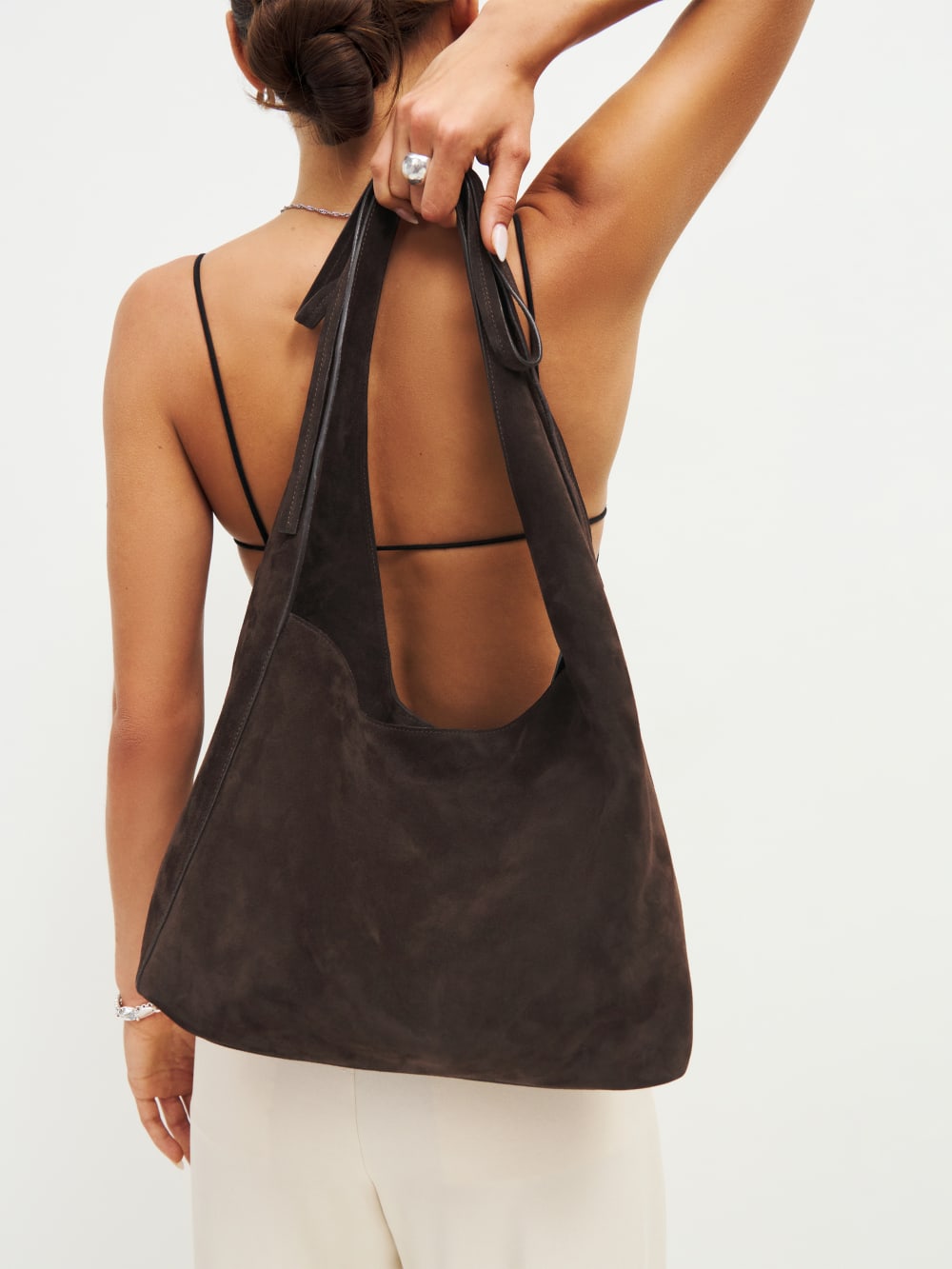 Reformation slouchy brown suede leather tote with a magnetic closure, features a decorative tie detail, and inside zip pocket with a card holder.
