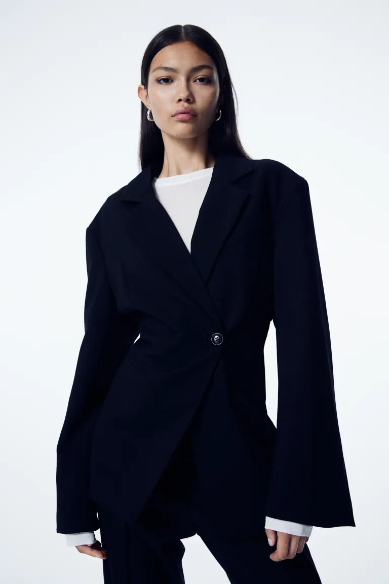 H&M black Fitted, double-breasted blazer in woven fabric with notch lapels and buttons at the front, one of which is concealed. Shoulder pads, long sleeves, a fake welt pocket on the chest and jetted front pockets. Shaping seams at the front and back. Lined.