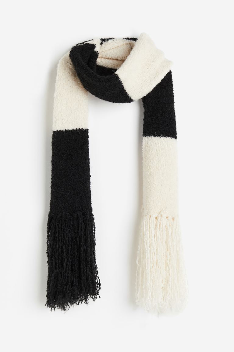H&M Scarf in soft textured bouclé weave containing some wool with long fringes on the short sides.
