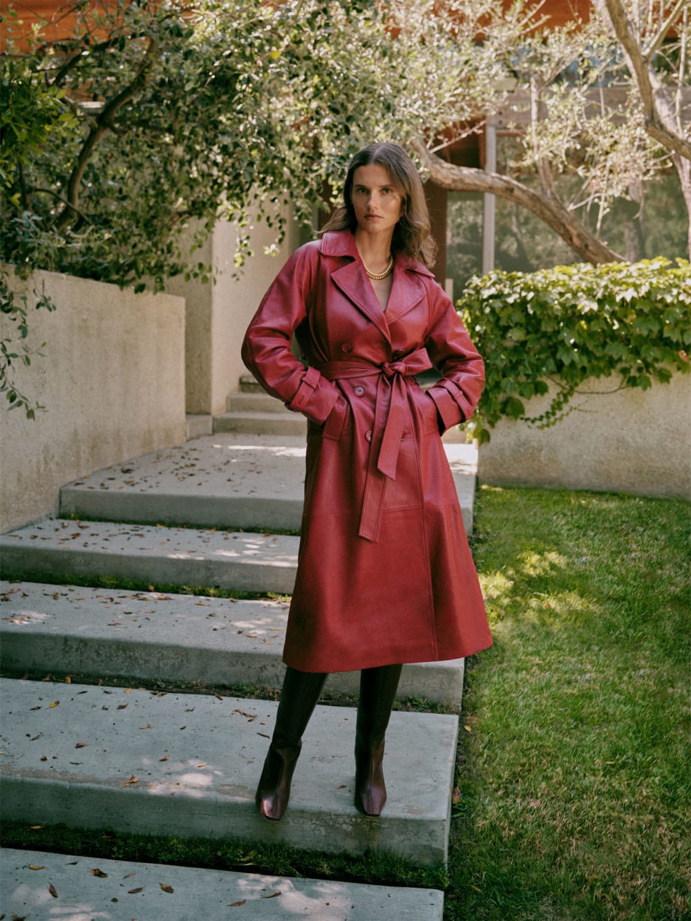 Reformation deep red leather trench coat with double-breasted Button front, self -tie detached belt, and side pockets. 