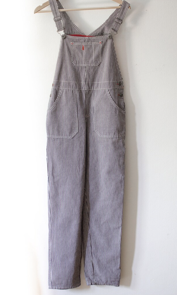 Vintage pinstriped dungarees. Classic workwear style overall / dungaree with suspenders and pockets.
Denim fabric, striped white pinstripes and navy blue (or dark charcoal grey).