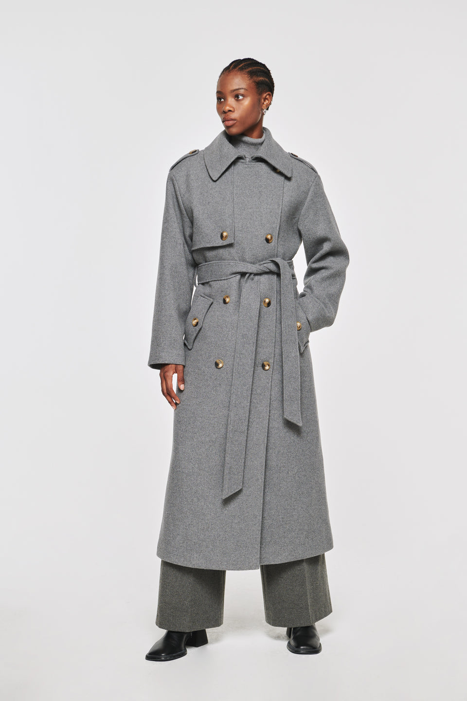 8 types of coats that never go out of style. Aligne classic, full-length trench coat, in grey wool. Finished with features like storm flaps, contrast buttons and epaulettes, it's designed to be a statement-making piece. Crafted from a blend of recycled polyester and wool, it's one for colder days. Wear over a dress or jeans for a casual look, or pair with a three-piece suit for power dressing.