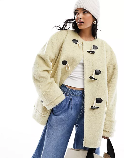 Trending Winter Coats 2023 2024 - ASOS DESIGN oversized duffle coat in stone. Mid-length cream textured coat with toggle details and round neck. 