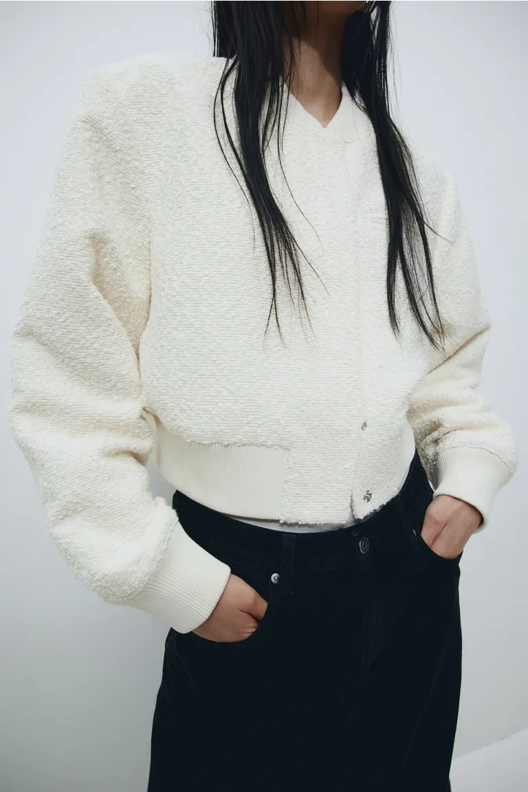 H&M cream Cropped bomber jacket in woven fabric with a small, ribbed collar and a fastening at the front. Shoulder pads, long sleeves and ribbing around the cuffs and hem. Lined.

