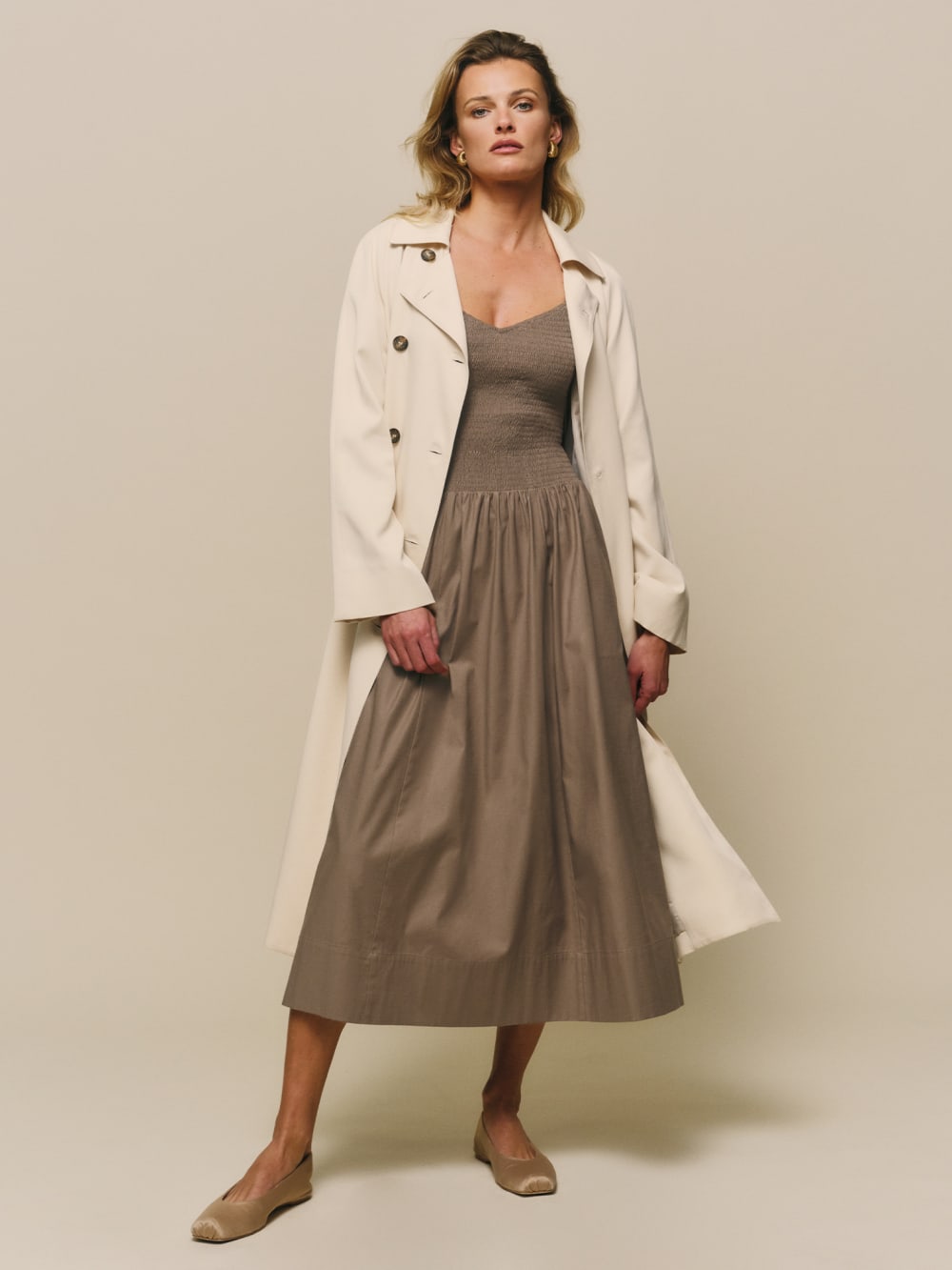 Reformation double-breasted Kensington Trench in beige.  
