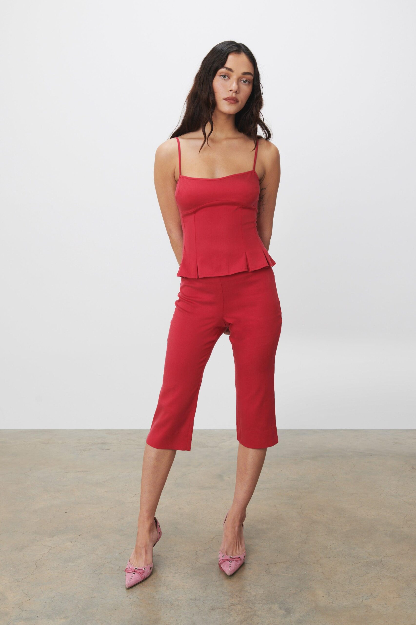 Peachy Den red mid rise slim fit capris, with small side vents at the hem. Created from a woven fabric that has a little stretch.